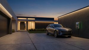 חנייה פרטית עם רכב חשמלי מחובר לעמדת טעינה מודרנית בשעת ערב